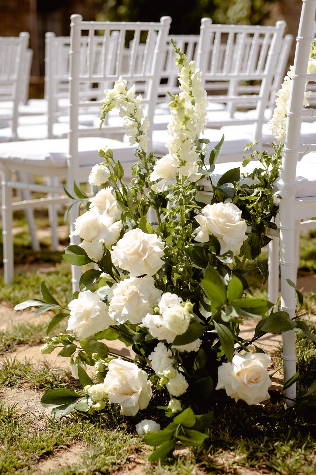 Spazio della cerimonia matrimoniale allestito con pedana, tessuti e fiori