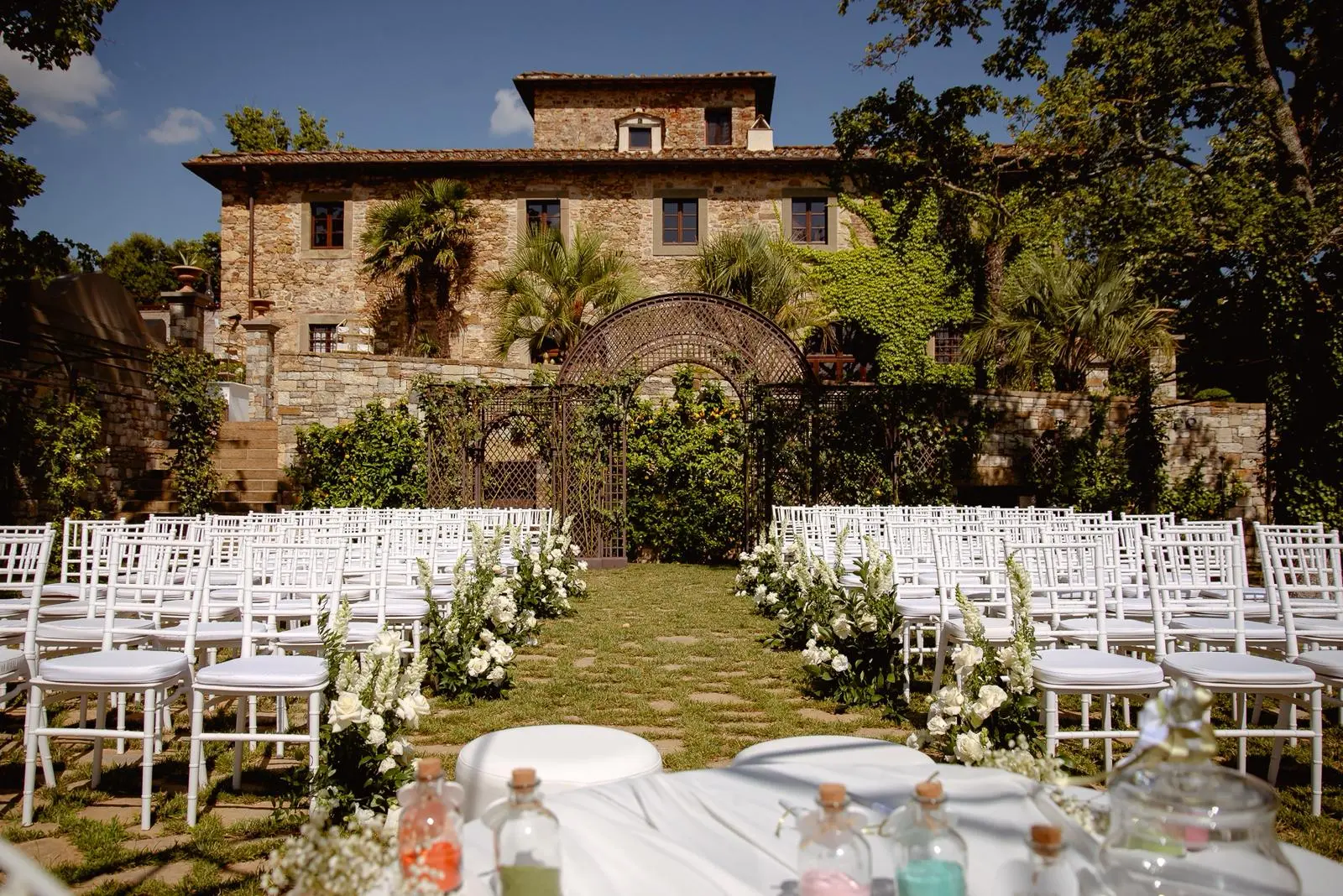Scenografia per matrimonio con drappeggi, pedana e decorazioni floreali