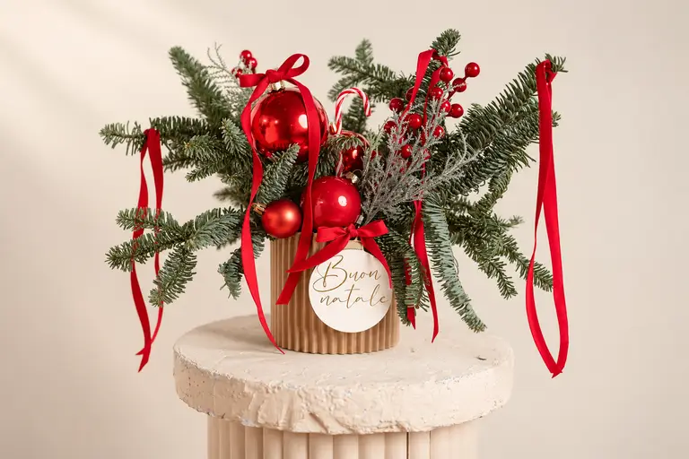 Composizione natalizia regalo con abete, palline e nastri rossi in vaso plissettato e bigliettino Buon Natale